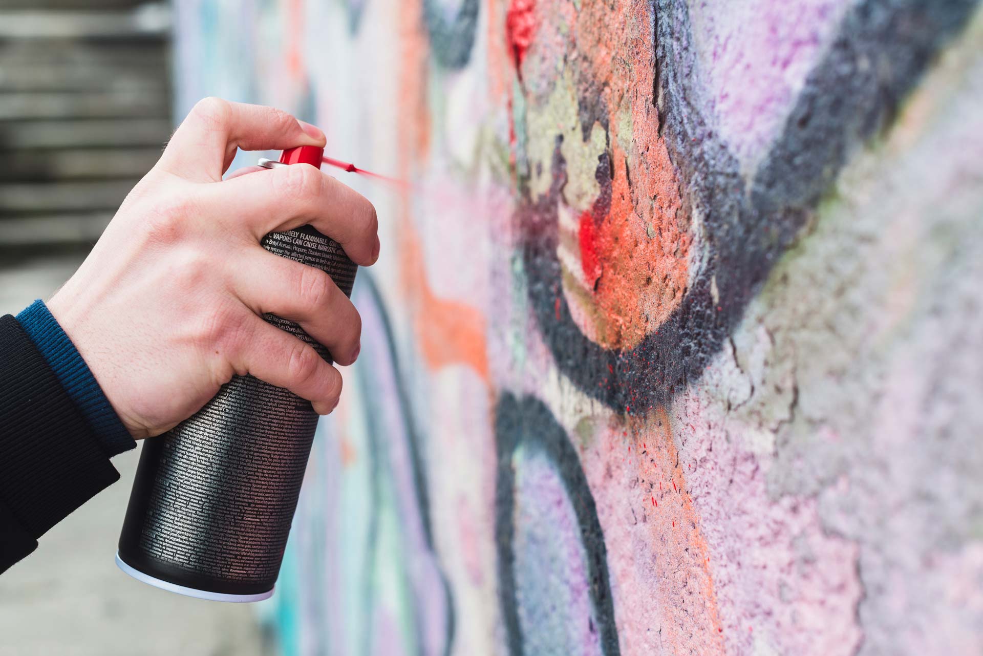 a person spraying a graffiti on a wall